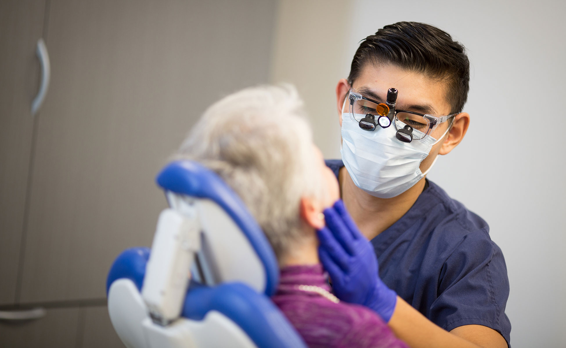 Dentist feeling the jaw of patient at appointment