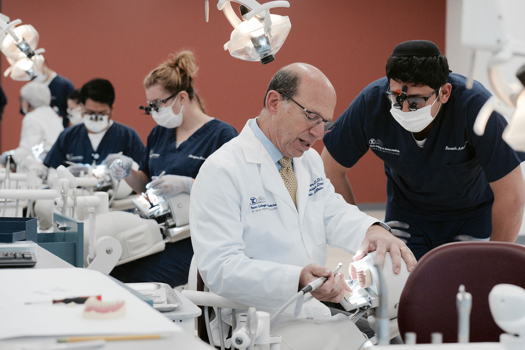 professor instructing students on teeth cleaning in state-of-the-art dental sim lab