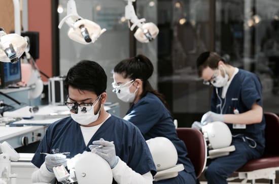 three TCDM students practicing dental work