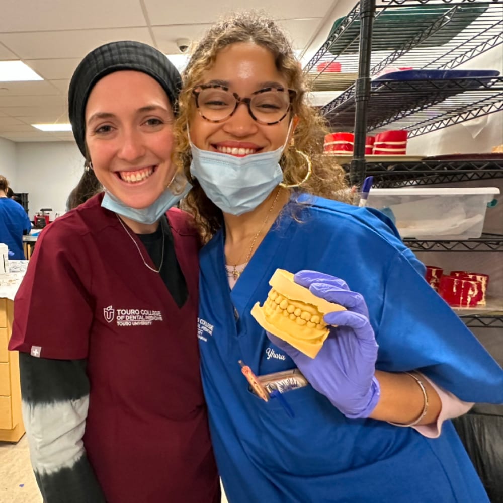 two pre-dental students in class smiling