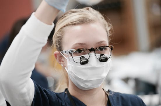 TCDM student with magnifiers attached to her glasses