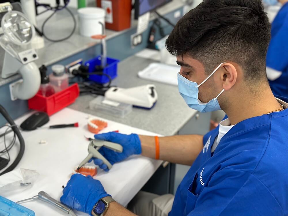 A participant in Touro College of Dental Medicine\'s Pre-Dental Experience uses a composite gun to create a filling.