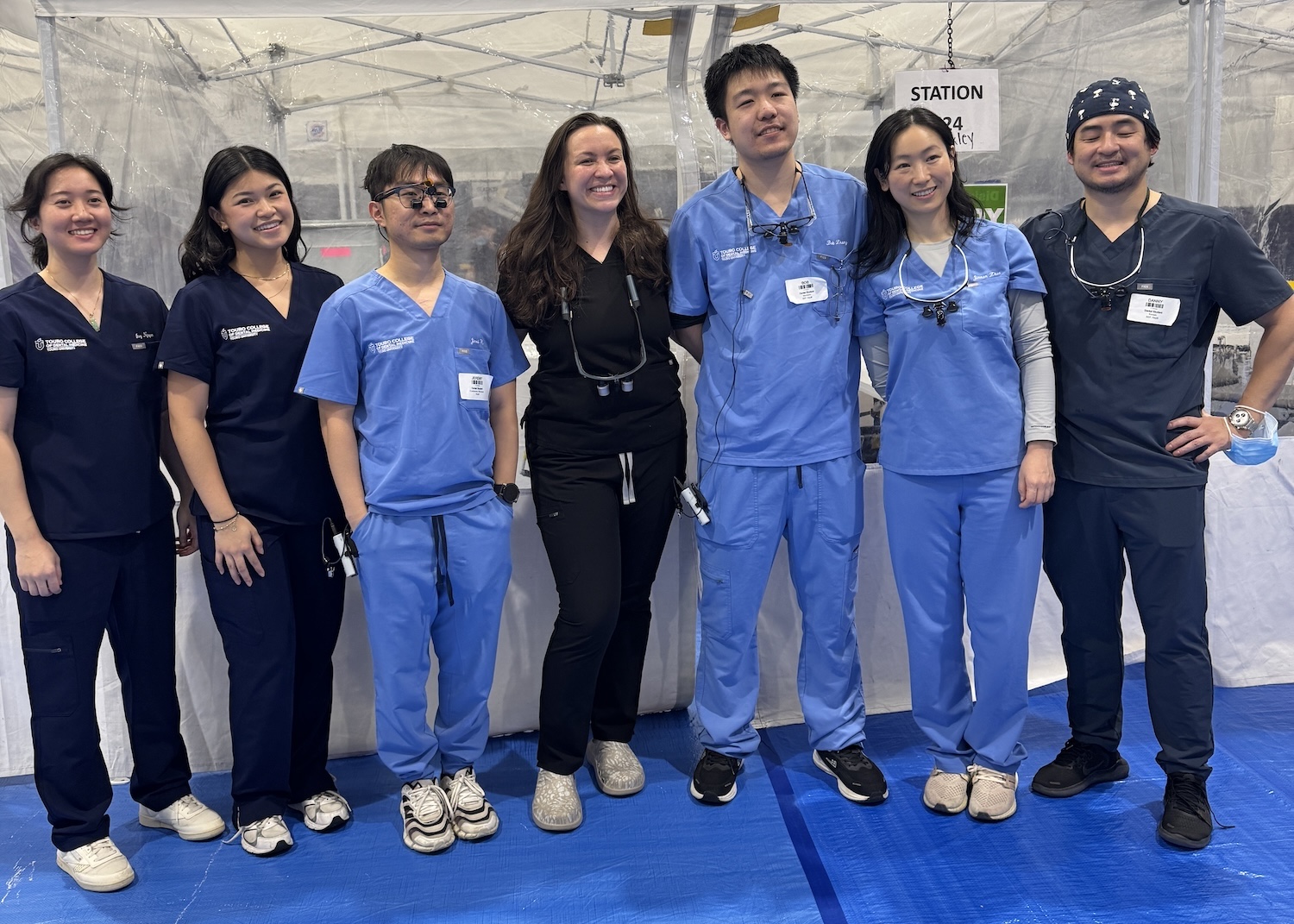 TCDM dental students, alumni and faculty members stand together.