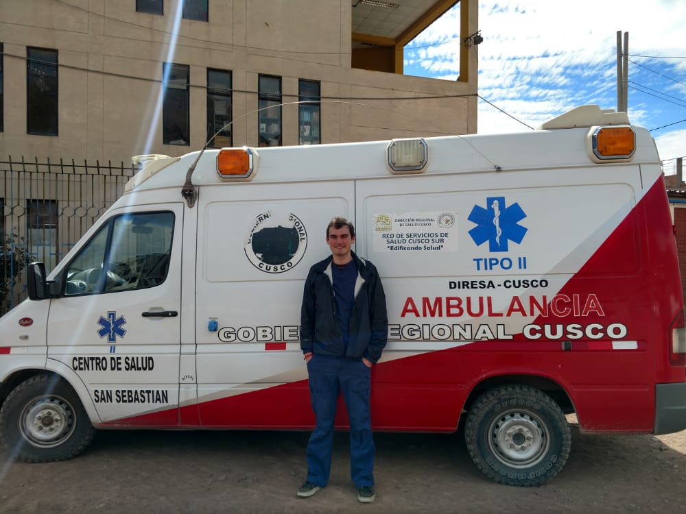 Andrew Gibbs posing in front of an ambulance