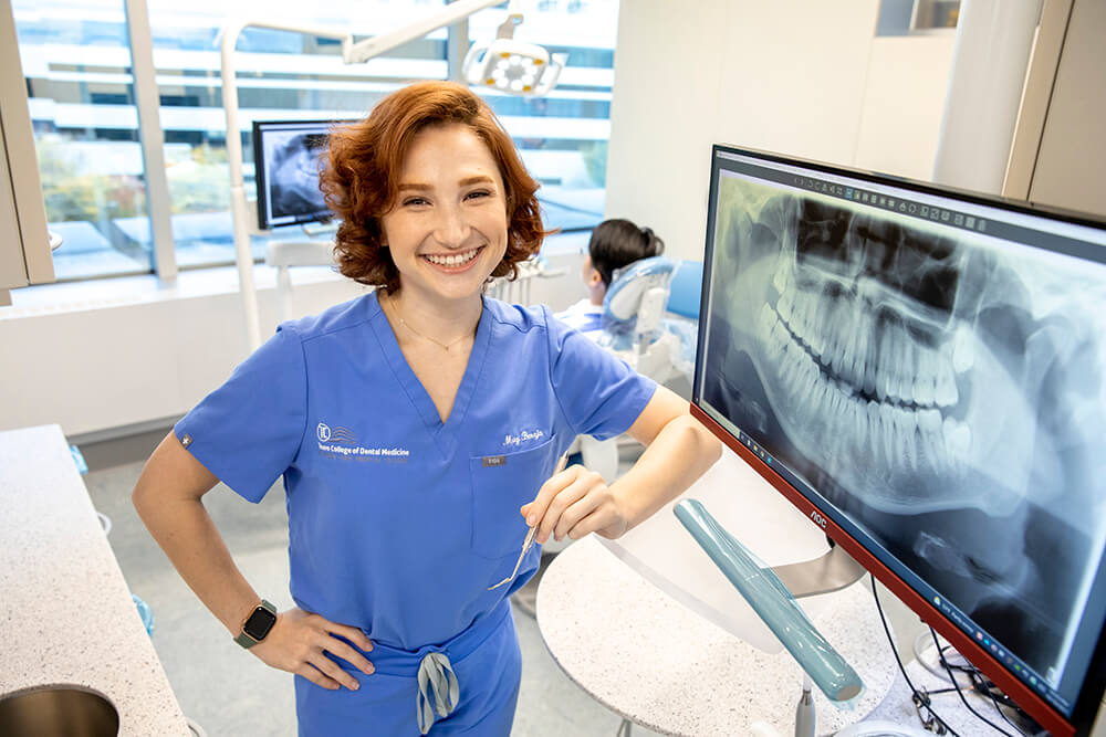 Madeline Maty Beraja dental student at TCDM standing next to computer screen with dental xray