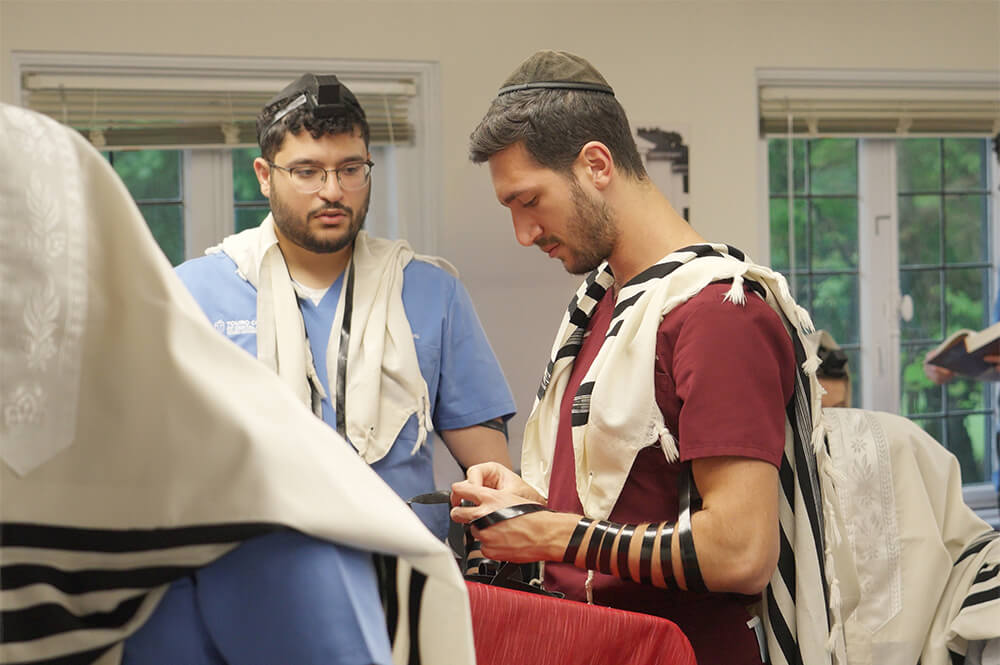 Jewish students preparing for prayers wearing phylacteries